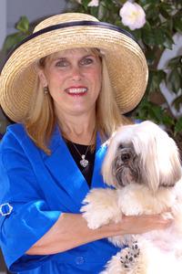 Award winner, Linda Crabill Byrne, posing in a hat with her Llasa Apso dog.